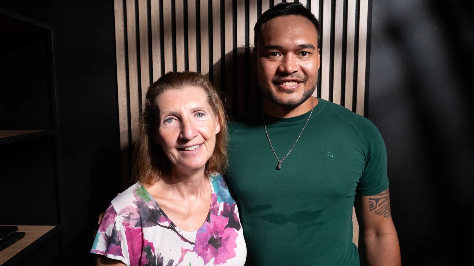 Deux co-animateurs souriants côte à côte dans le décor d'un studio podcast à Genève