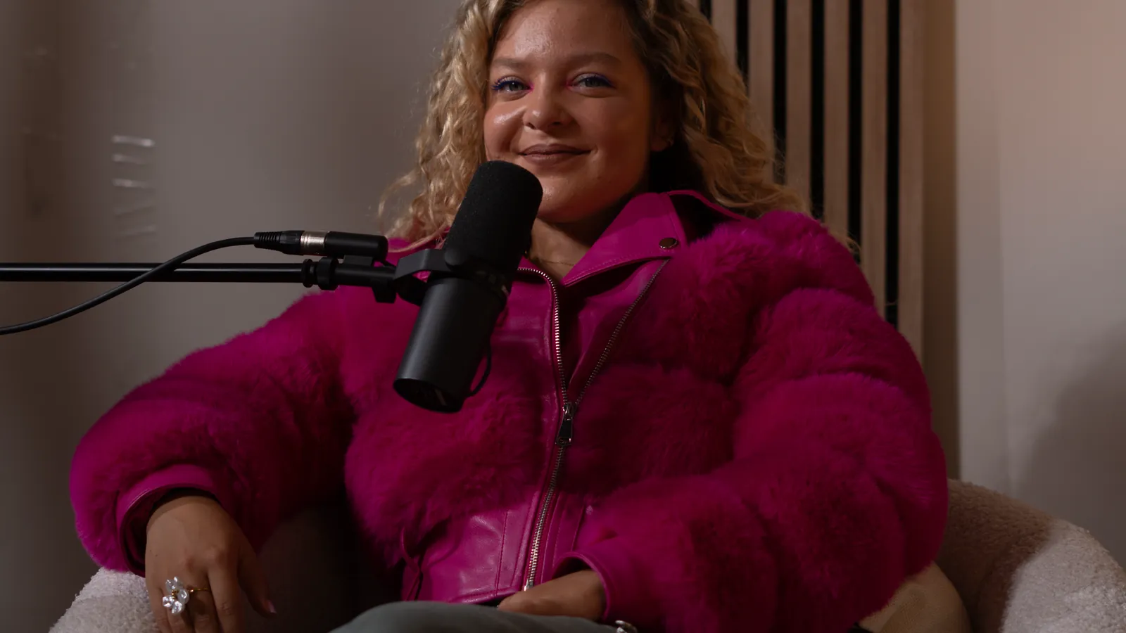 Invitée en veste rose au micro lors d'une séance photo et vidéo chez Wanda Studio