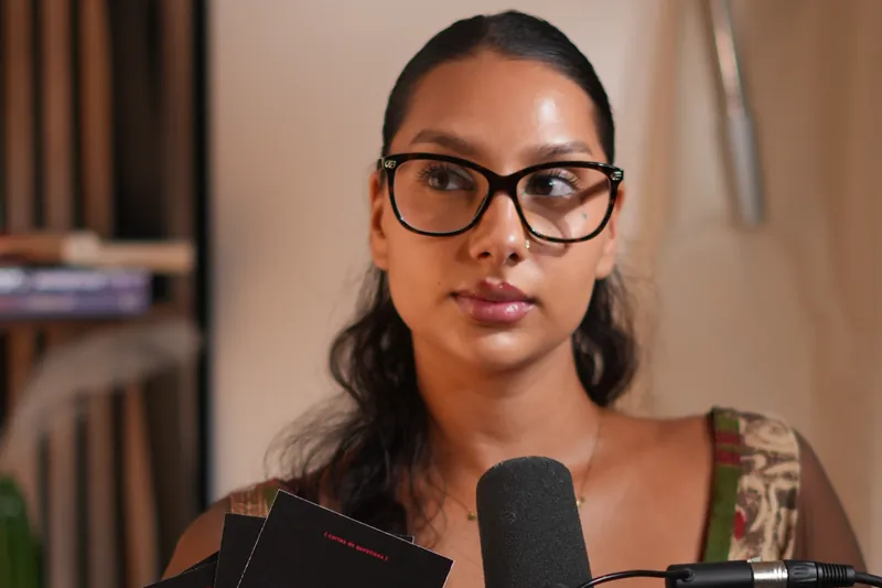 Invitée à lunettes, cheveux tirés, au micro dans un studio podcast