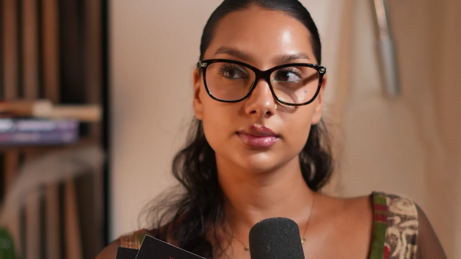Invitée à lunettes, cheveux tirés, au micro dans un studio podcast