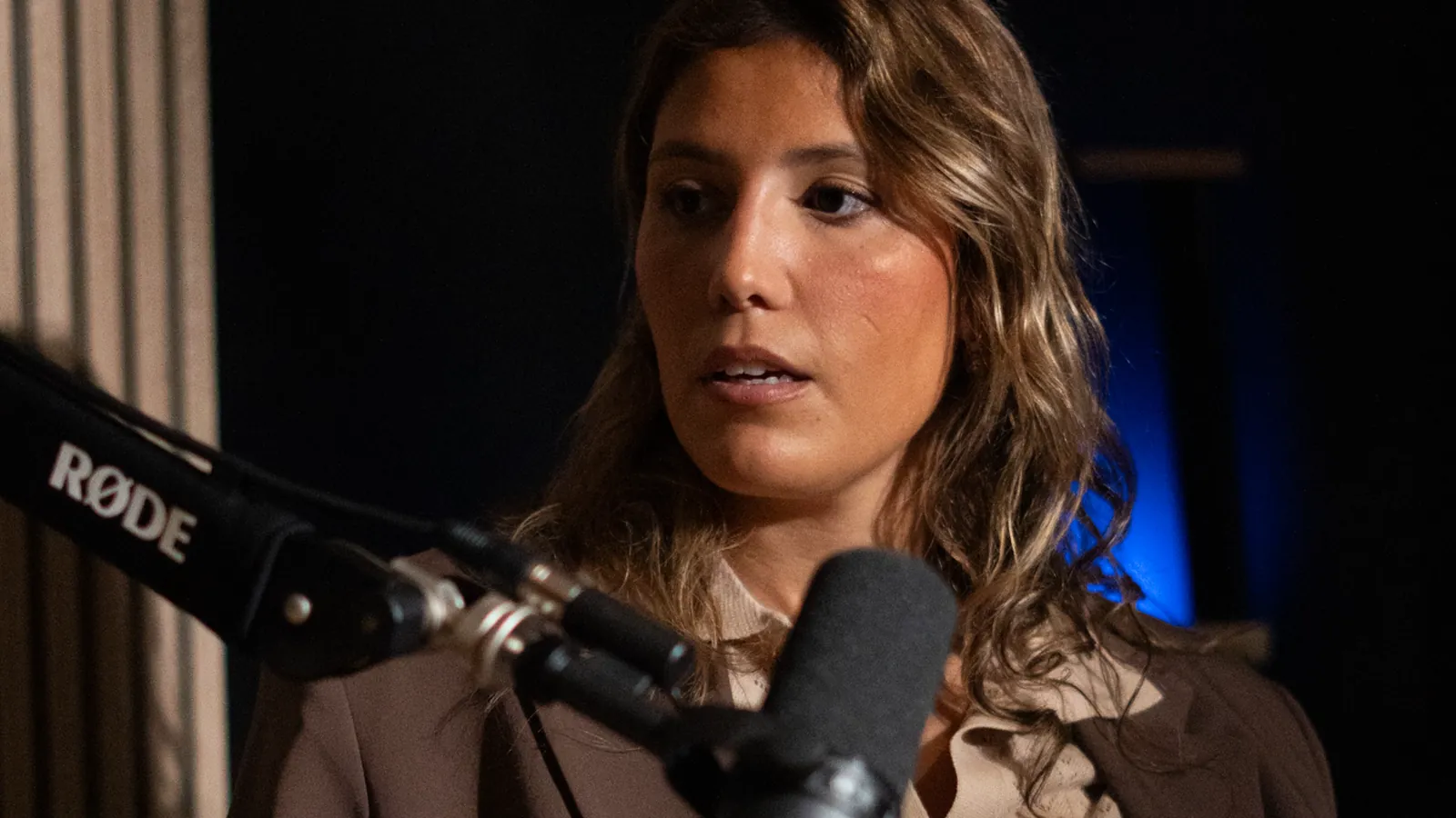 Invitée aux cheveux châtains au micro sur bras articulé dans un studio