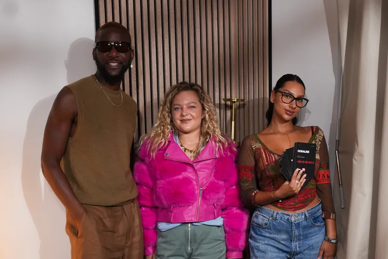 Trois invités debout dans un studio podcast après un tournage