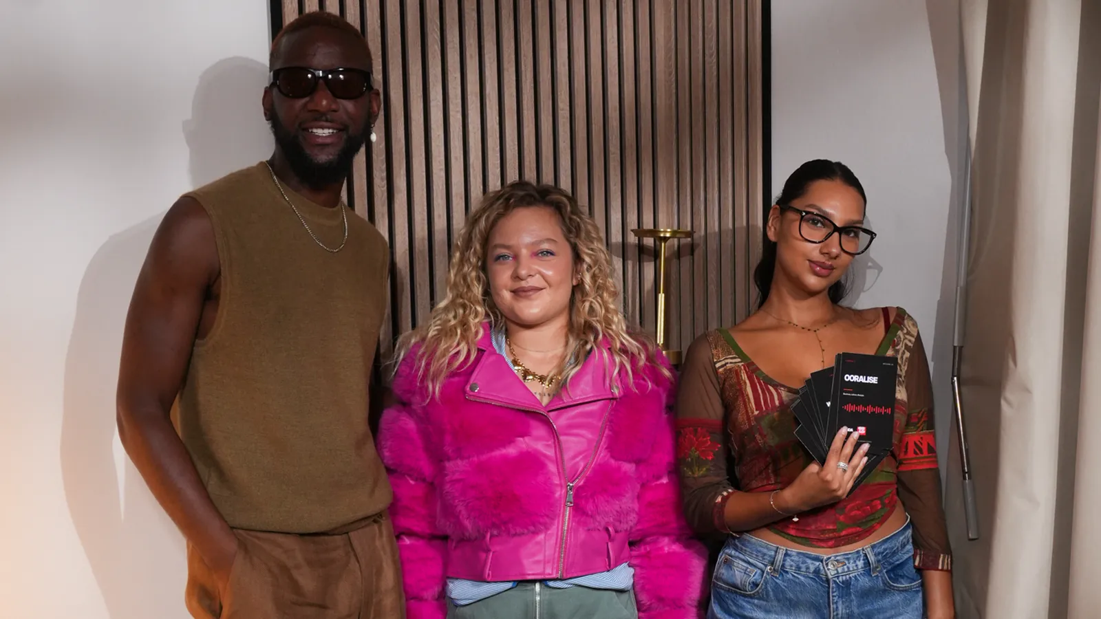Trois invités debout dans un studio podcast après un tournage