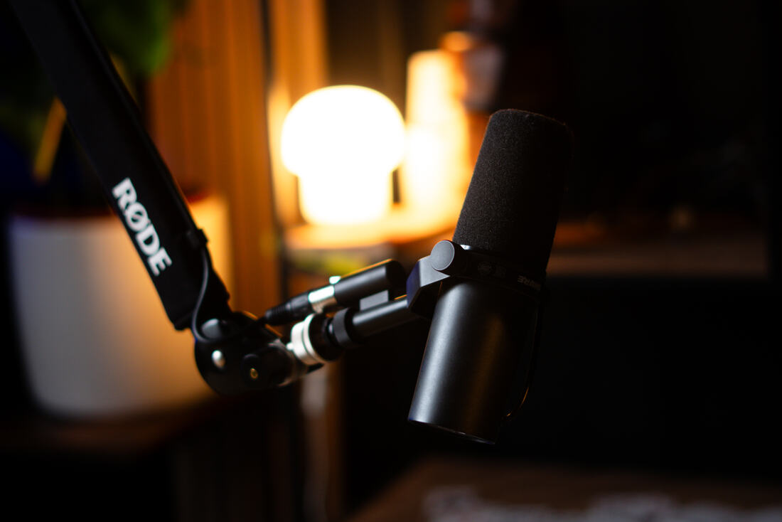 Studio microphone in front of a lit globe lamp, warm blurred background
