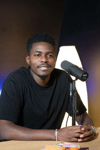 Jeune entrepreneur en t-shirt noir, accoudé à la table du studio