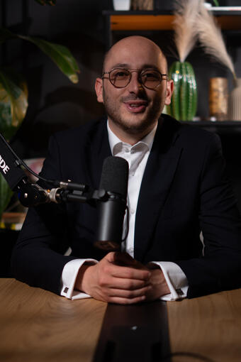Dirigeant en costume et lunettes, éclat de rire derrière le micro