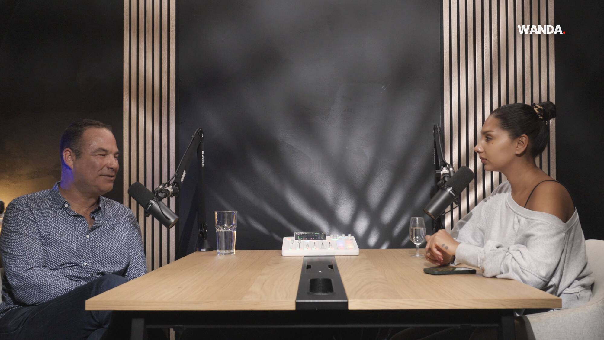 Sébastien Courage et Anjou face à face à la table du Studio Rhône, pendant le tournage du podcast de Wanda Studio à Genève
